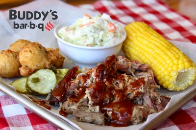 Buddy's BBQ pork dinner with slaw, corn on the cob, hushpuppies